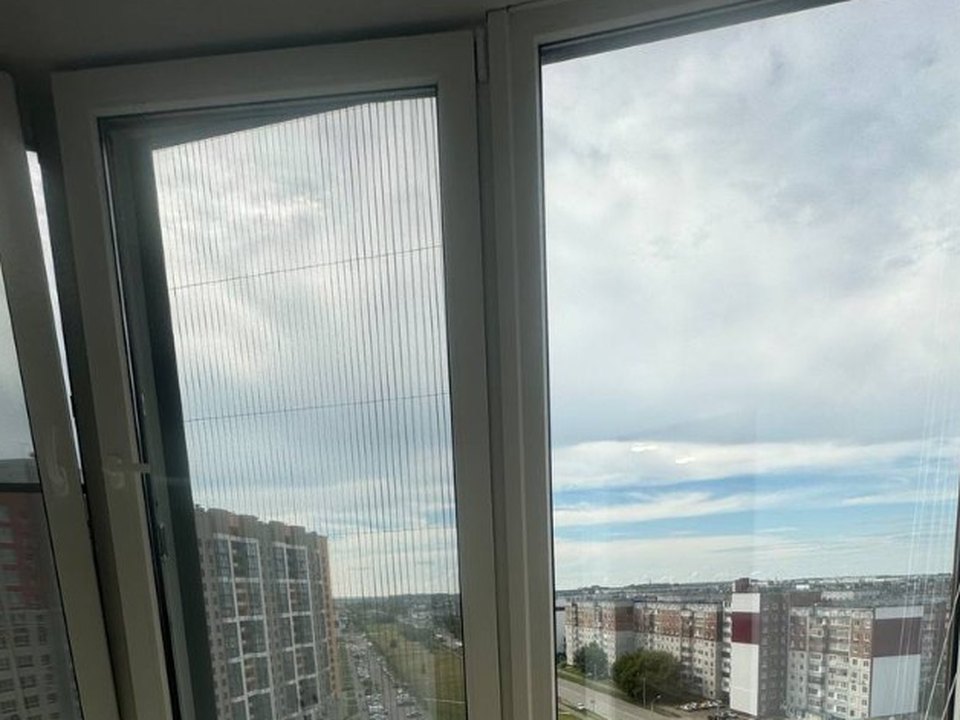 Плиссированная москитная сетка на белом пластиковом окне балкона с видом на город, белый. В наличии — Хорошая Компания, Красноярск