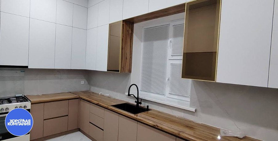 Белые горизонтальные жалюзи на кухонном окне рядом с мойкой и плитой
